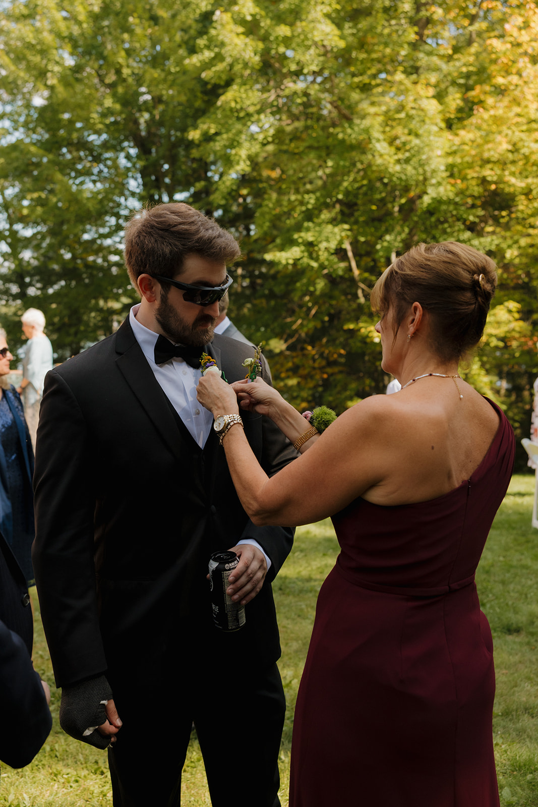 Mother of the groom adjusting his boutonniere before the ceremony.