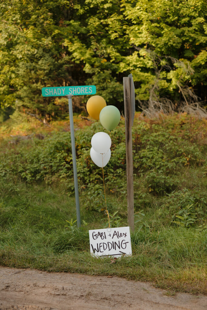 Wedding sign with balloons marking the path to Gabi and Alex’s barn wedding celebration.