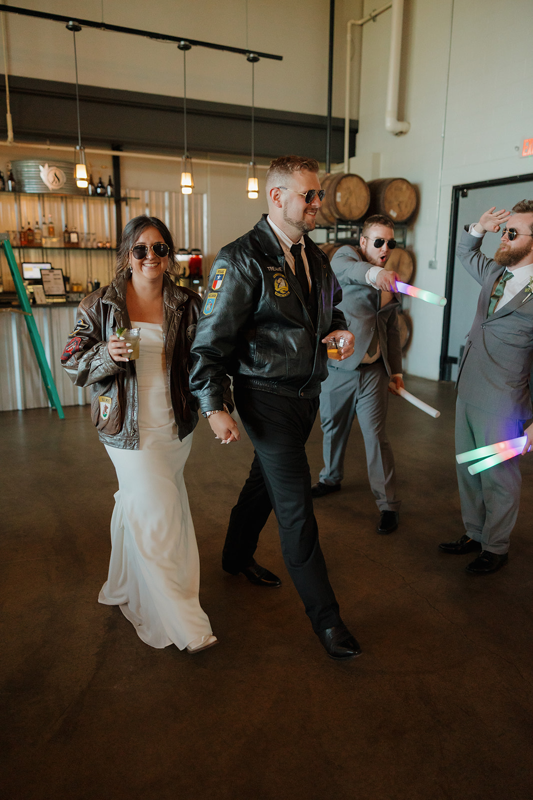 Bride and groom rock leather jackets and sunglasses for a playful wedding party entrance at their Wisconsin brewery reception.