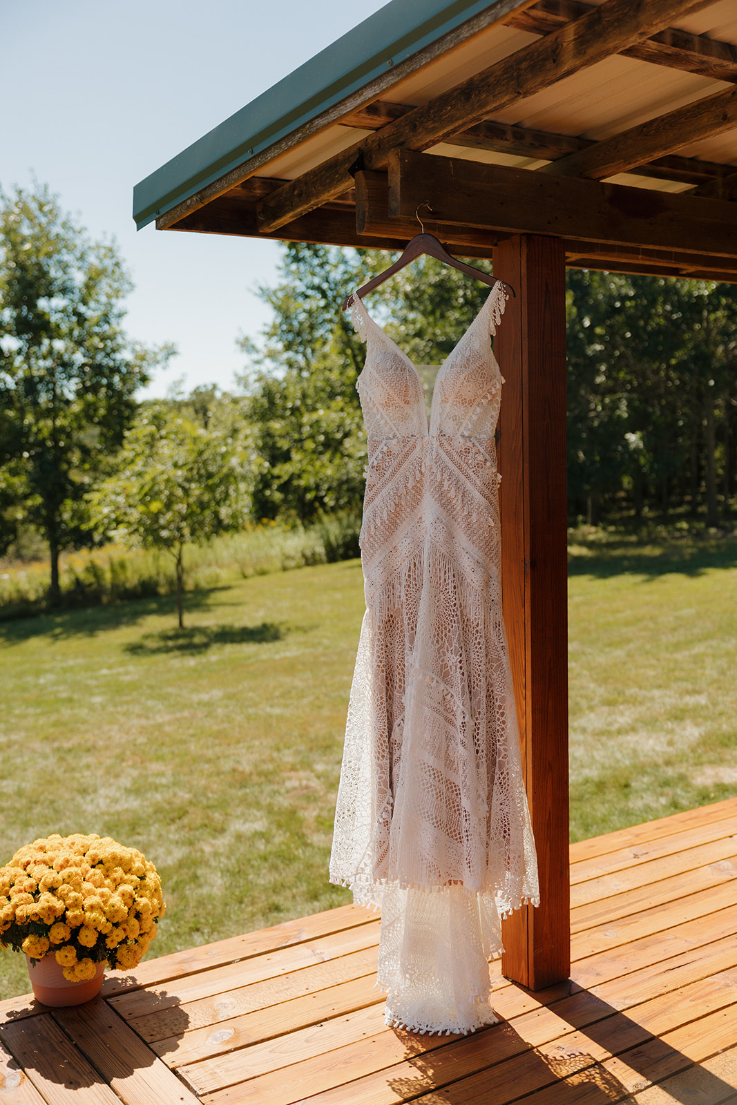 Lace wedding gown hanging from wooden cabin 