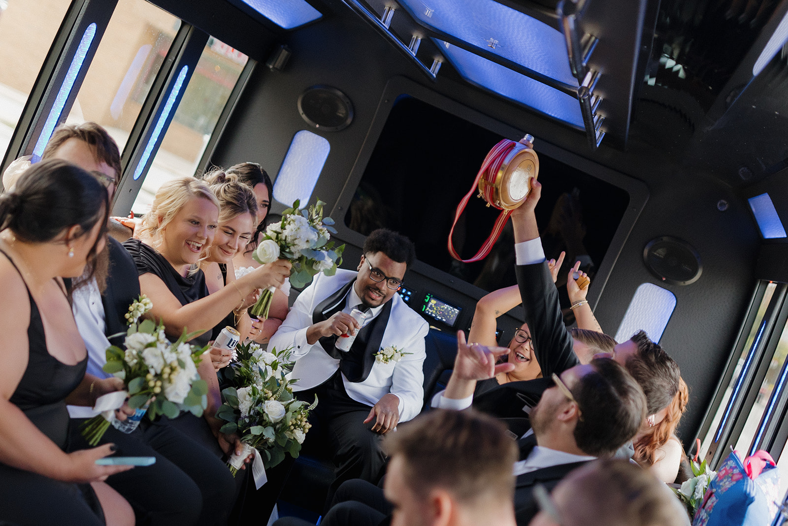 Wedding party celebrating on a party bus en route to portrait locations during a Milwaukee wedding.