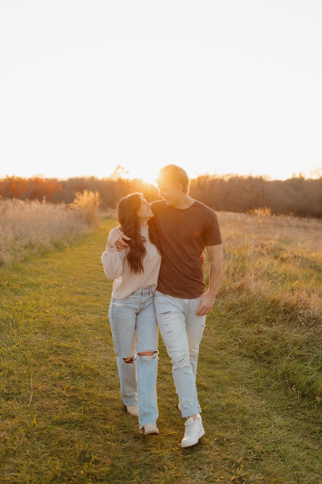 Engagement photos featuring a couple smiling with the forest of Wisconsin behind them. 
