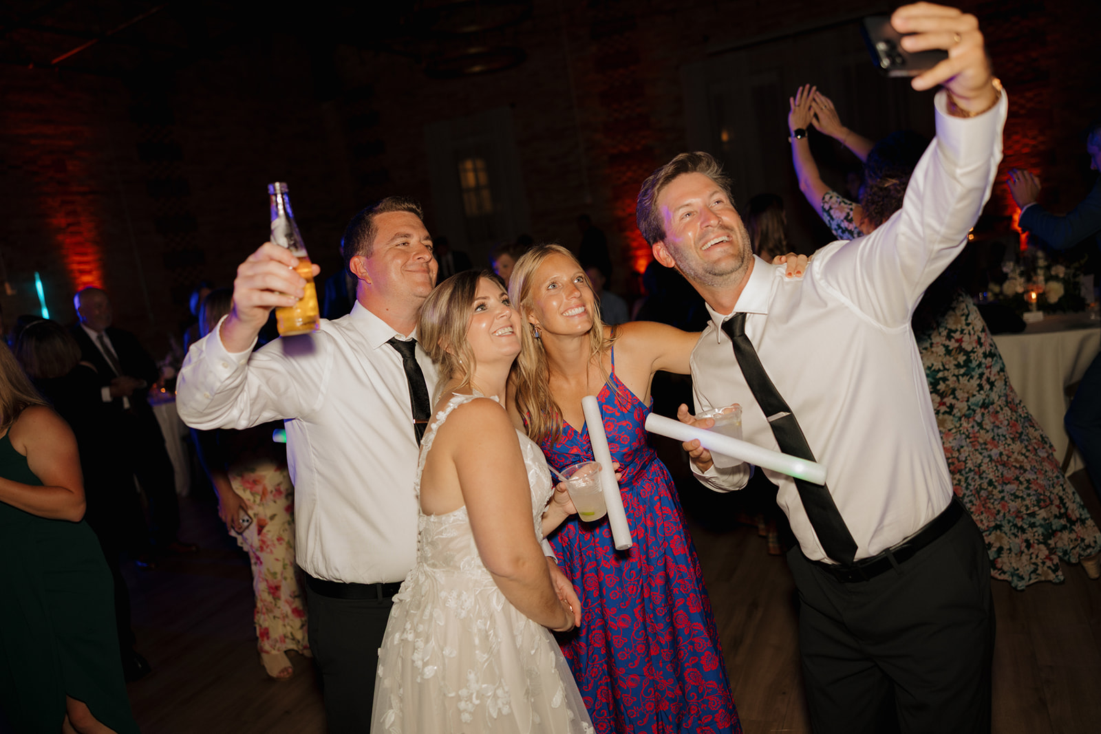 A group of friends happily taking a selfie at a wedding in the beautiful 10 South wedding venue.