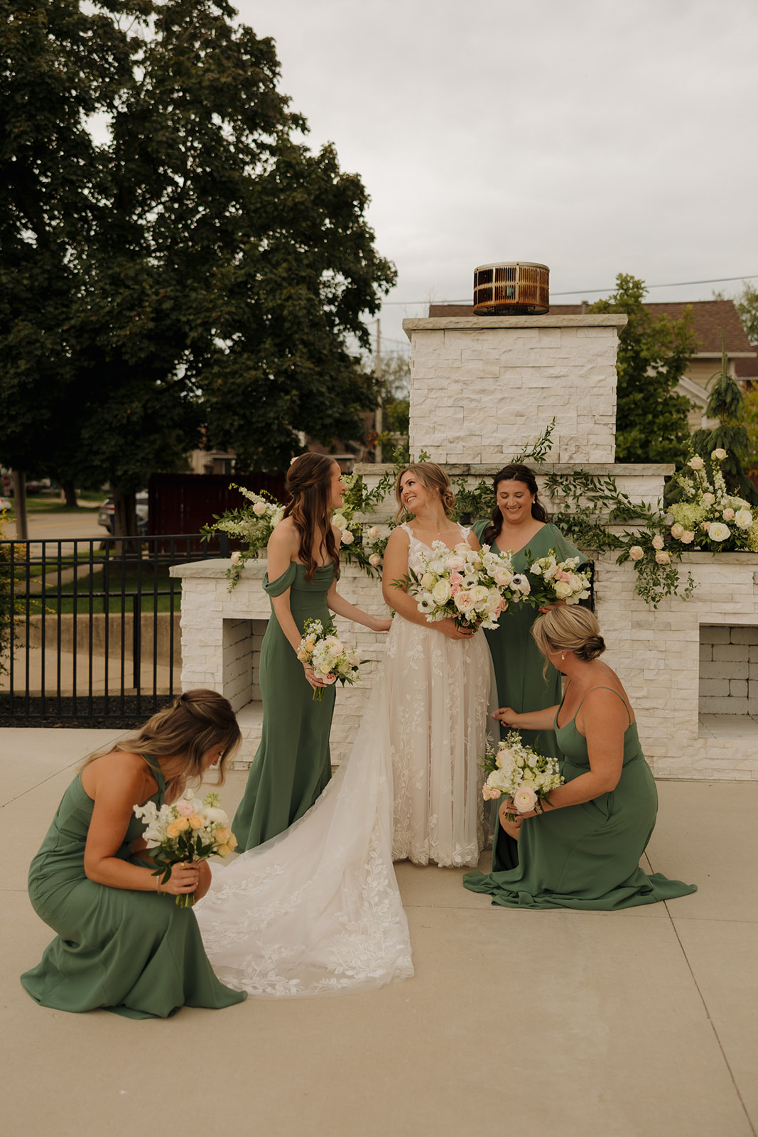 Bridesmaids in green dresses pose together at the 10 South wedding venue, smiling and celebrating the special day.

