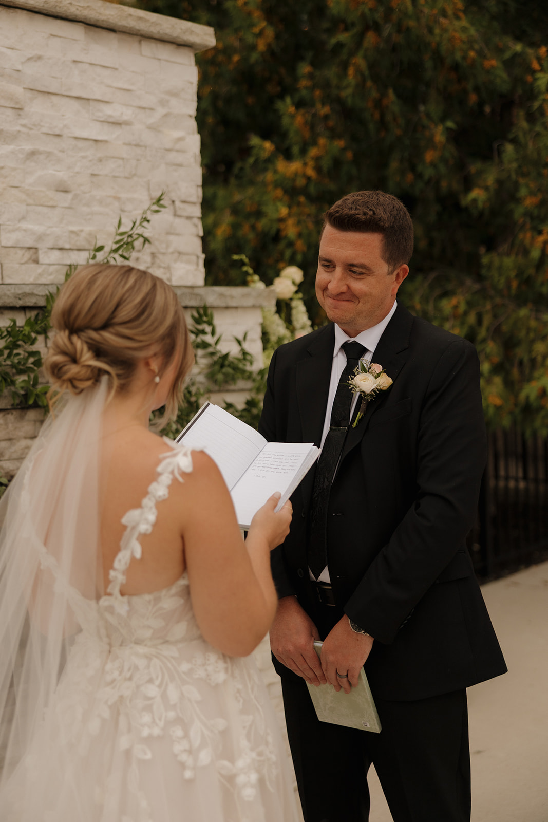 Bride reads vows to groom during a private vow reading outdoors before wedding ceremony is to begin