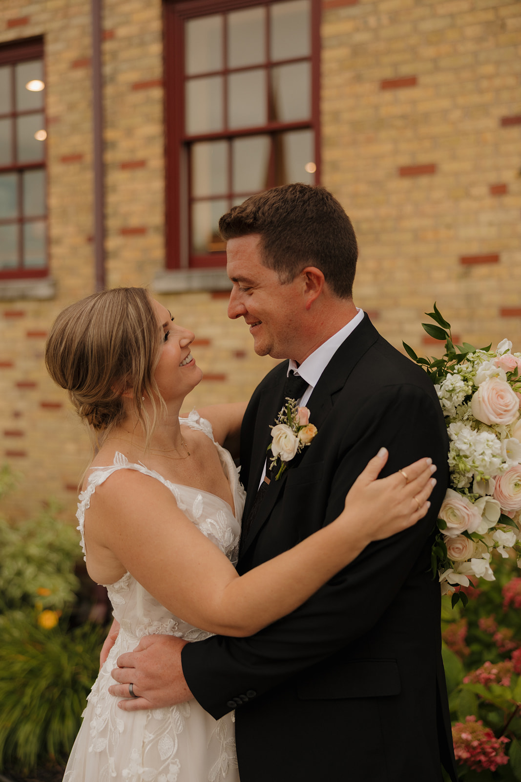 Newly married couple embrace and look at one another with love in their eyes outside of 10 South wedding venue