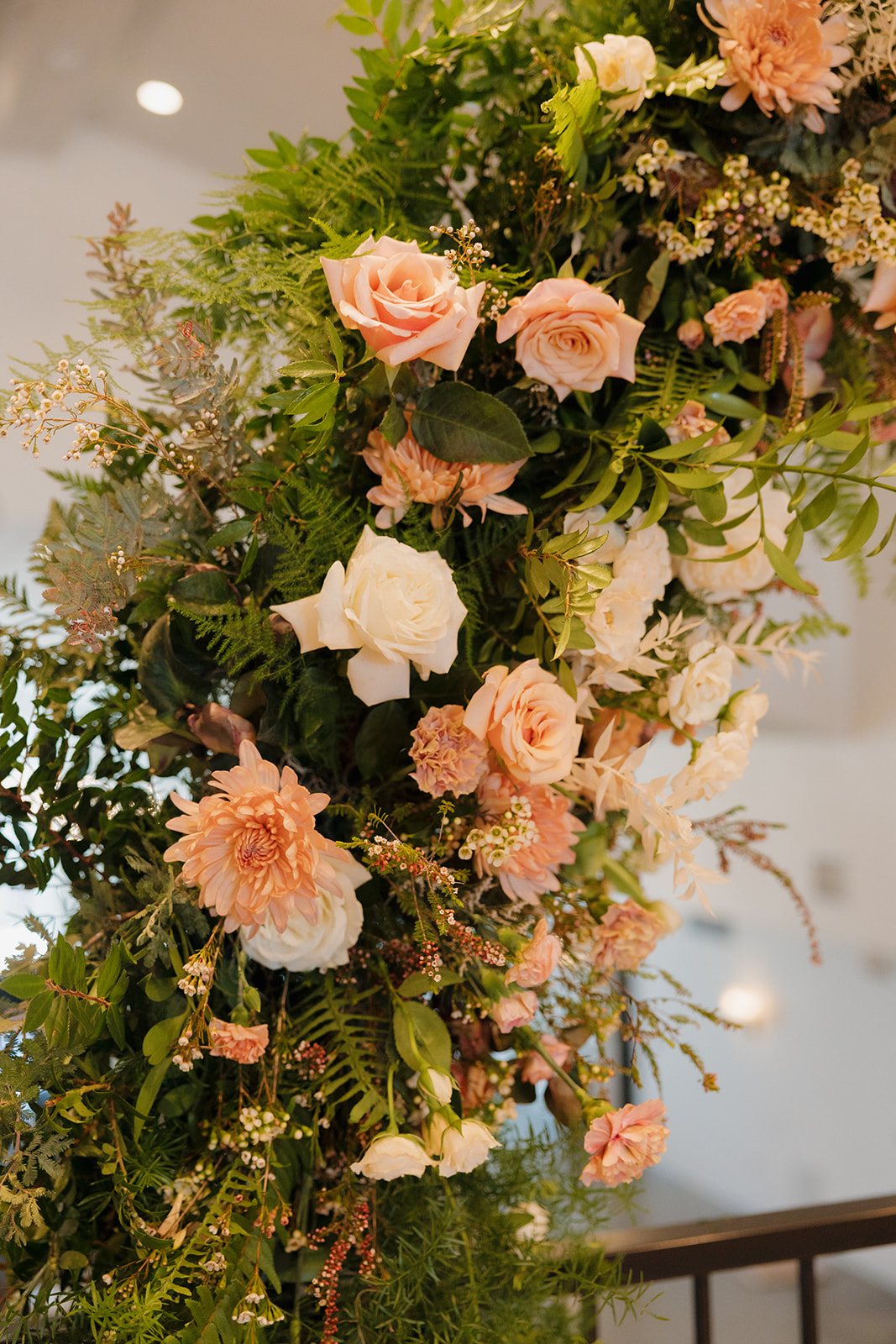 Close-up of a lush floral ceremony arch featuring blush roses, dahlias, and wild greenery—textured and romantic perfection.