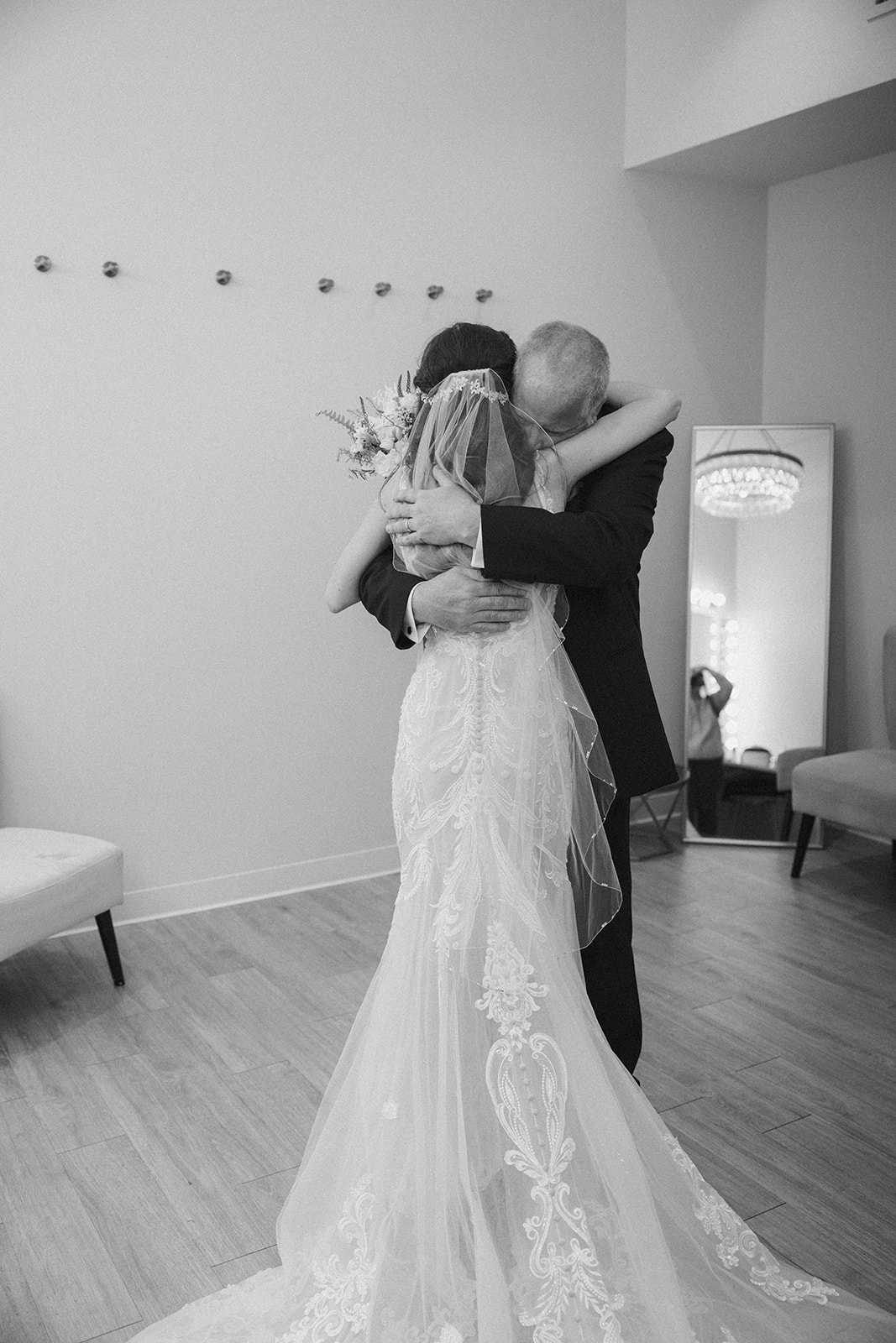 Bride shares an emotional embrace with her father before walking down the aisle—captured in timeless black and white by a madison wedding photographer.