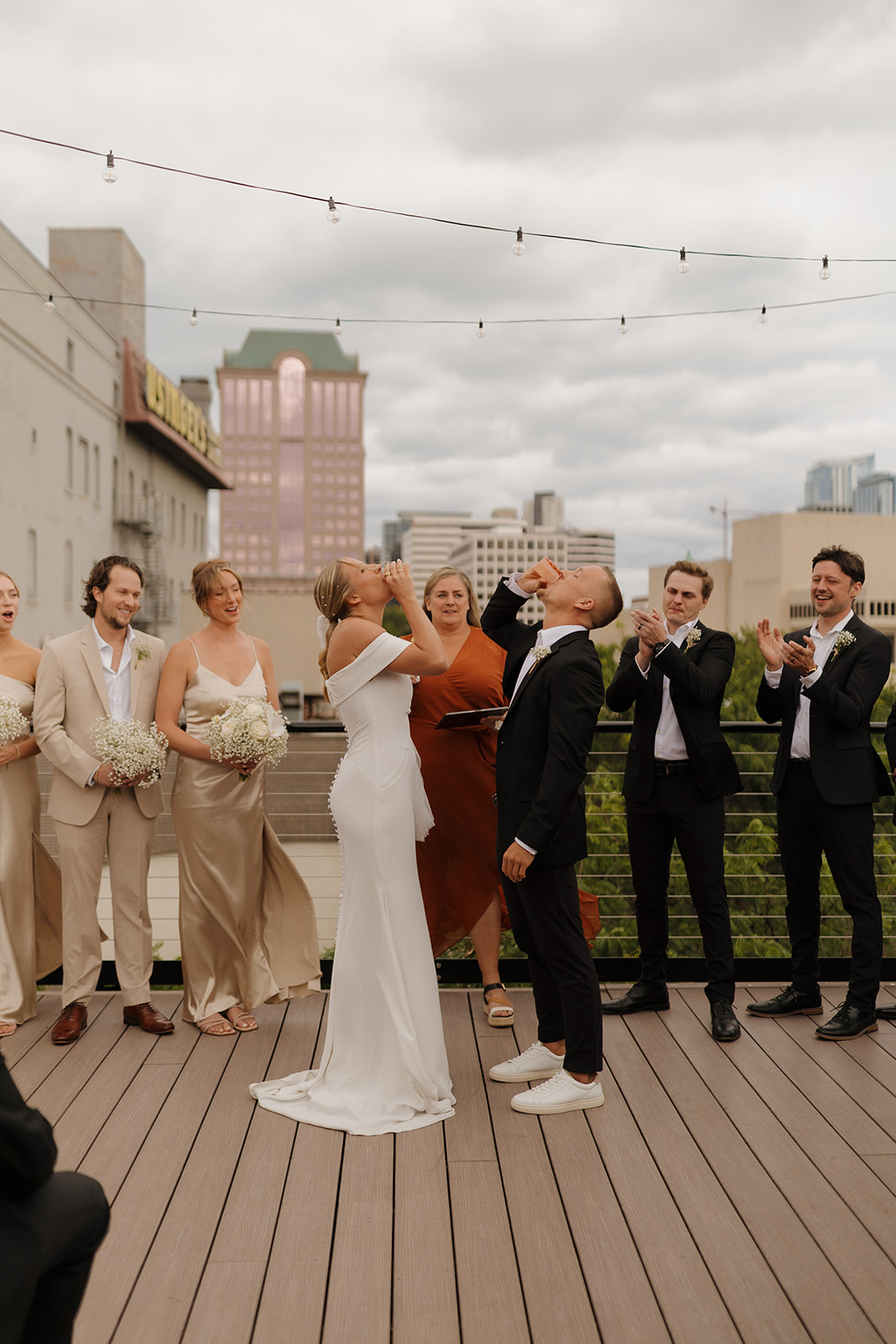 Wedding couple takes shot together during wedding ceremony on rooftop in Wisconsin.