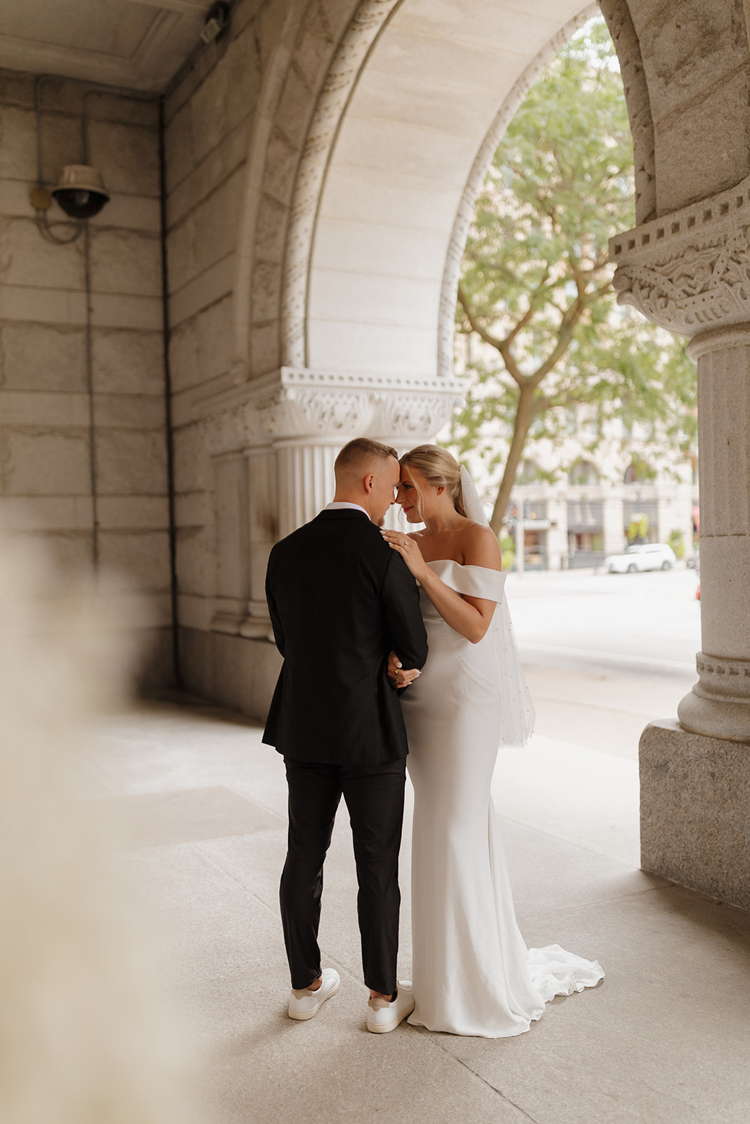 Bride and groom caught in private dance moment in secluded marble hallway