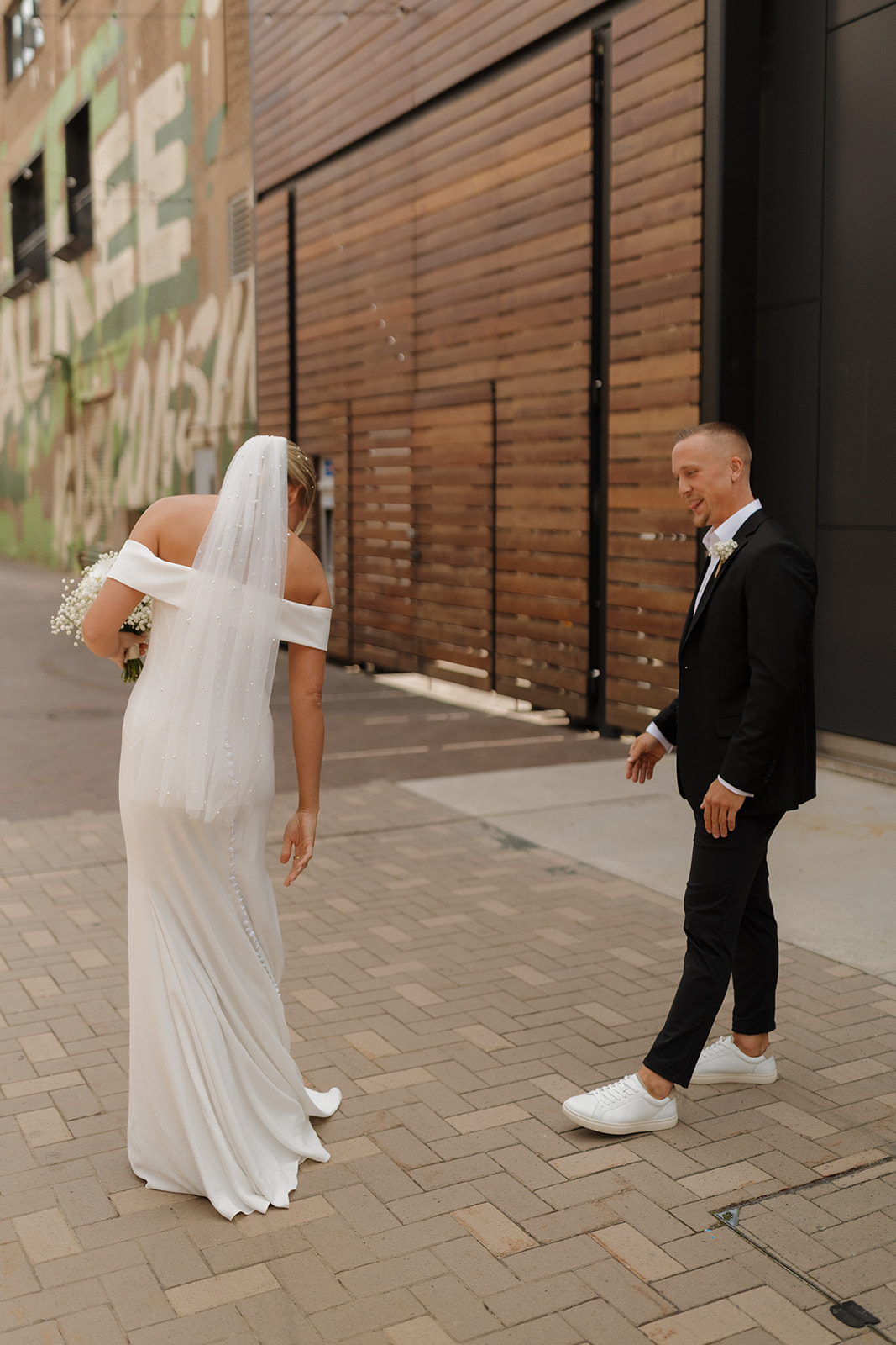 Bride walking toward her groom during their first look in downtown Milwaukee for their wedding in Wisconsin.