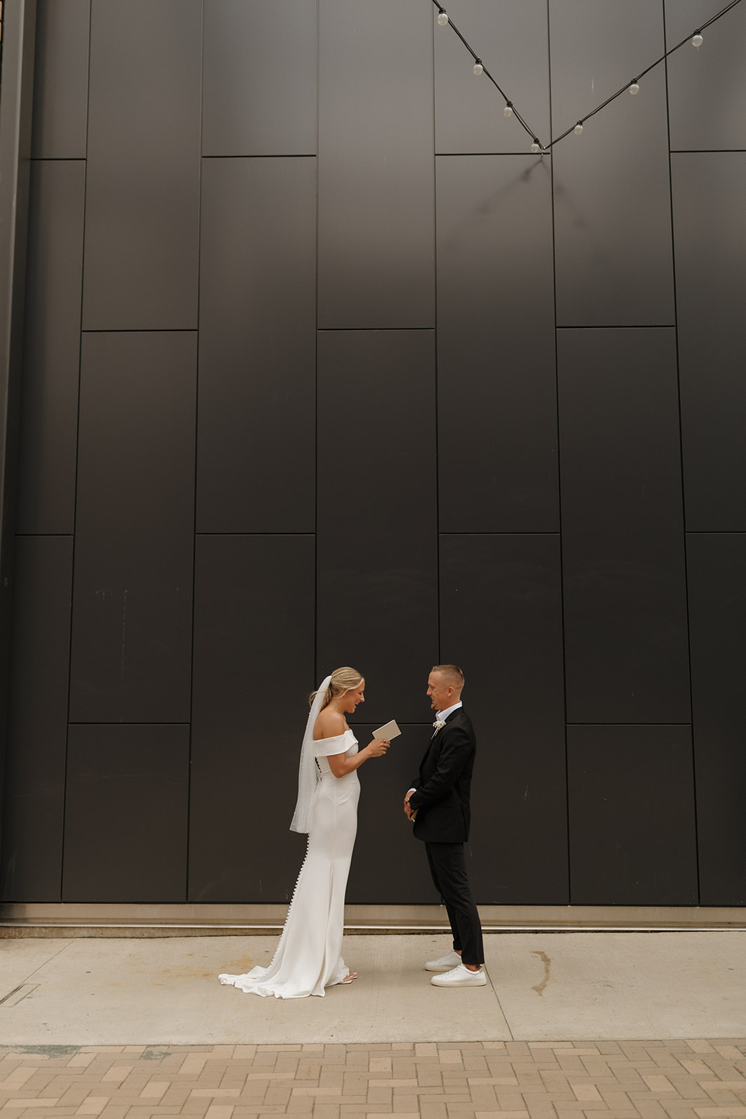 Bride holds vow book and begins to read her vows to her groom.