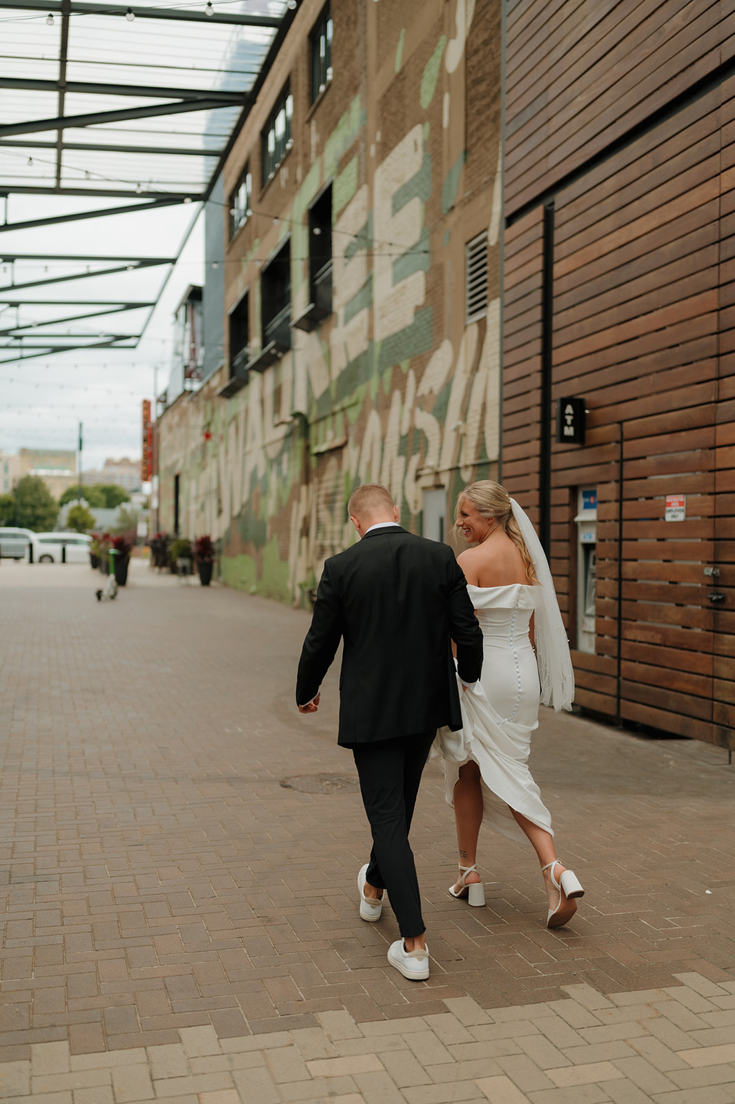 Bride and groom walking hand in hand back to their hotel for a quick outfit change before the reception
