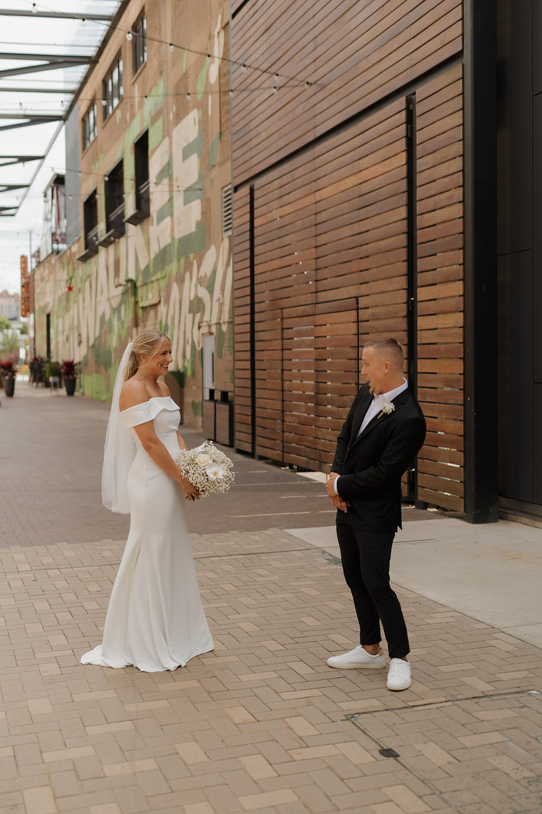 Groom reacting with a huge smile during a downtown Milwaukee first look on their wedding day.