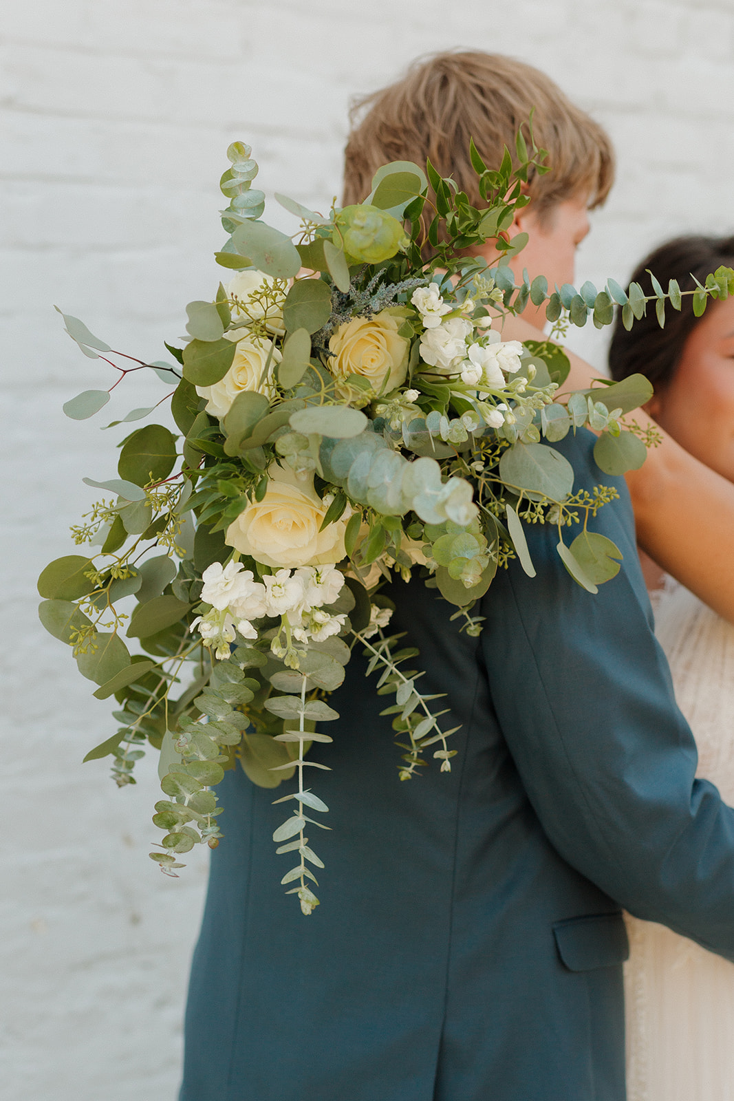 Close up of bride's green and white bridal bouquet with eucalyptus and other greenery 