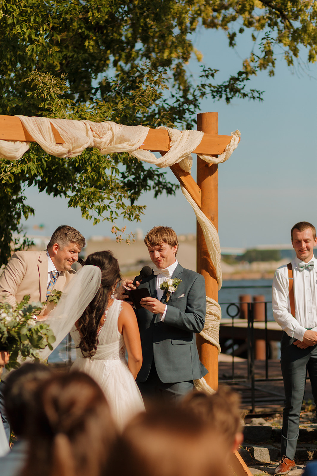 Groom reads vows to bride during intimate wedding ceremony outdoors