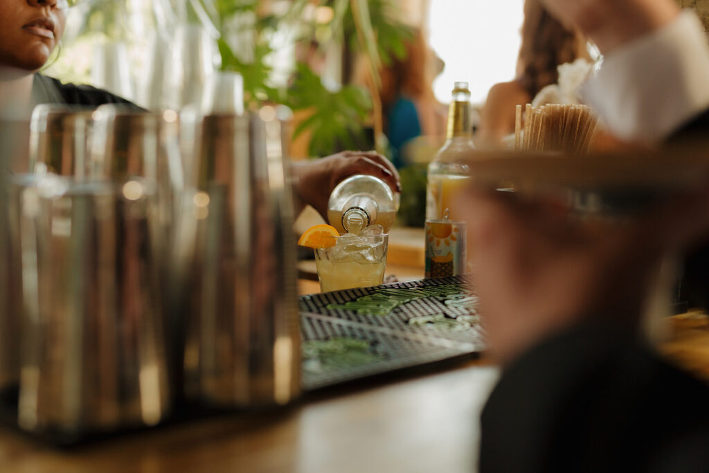 Close up of bartender pouring signature drinks at cocktail hour