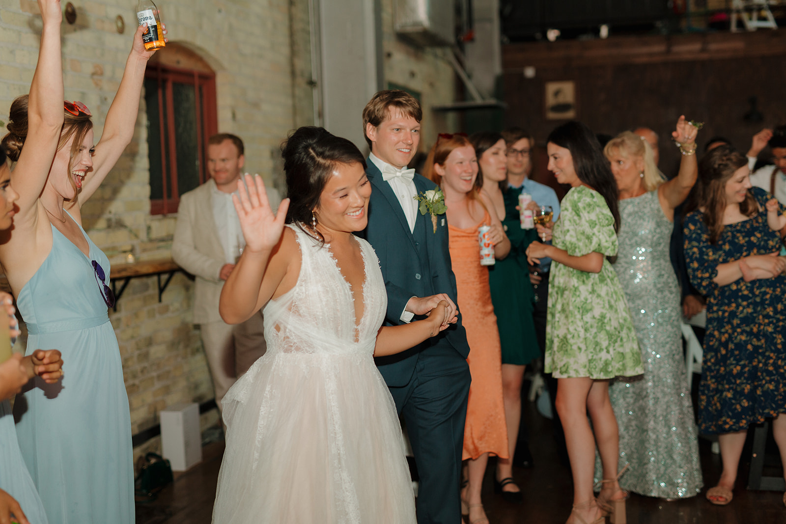 Bride and groom dance their way into their reception ready to celebrate with their family and friends 