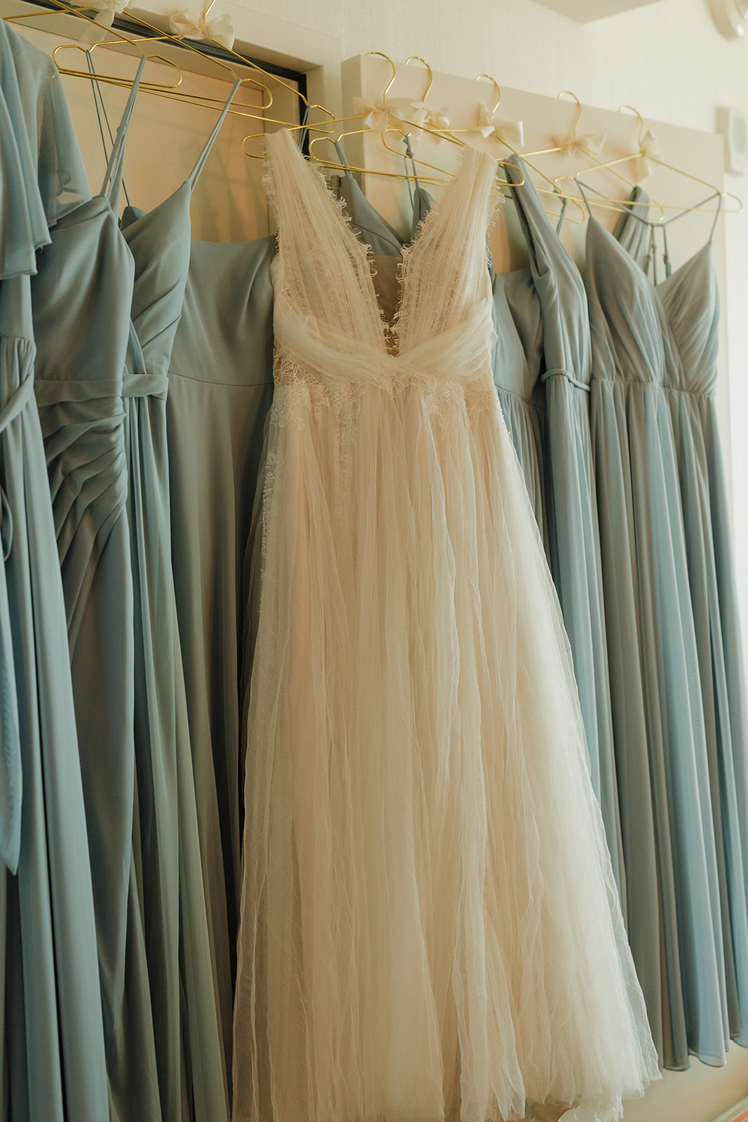 Wedding gown hanging with bridesmaids dresses before intimate wedding at Milwaukee wedding venue