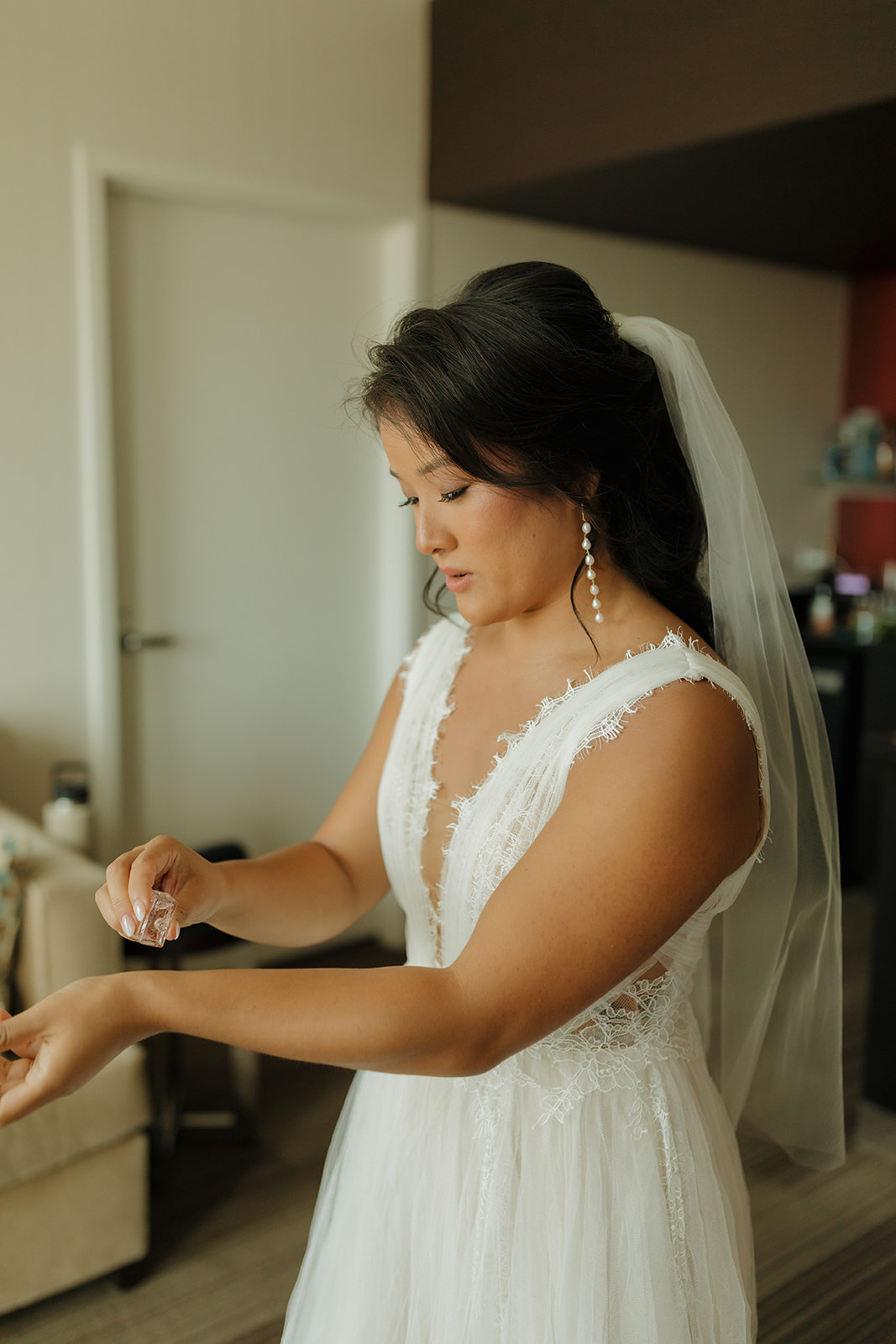 Bride sprays perfume on wrists before walking down the aisle at Milwaukee wedding venue