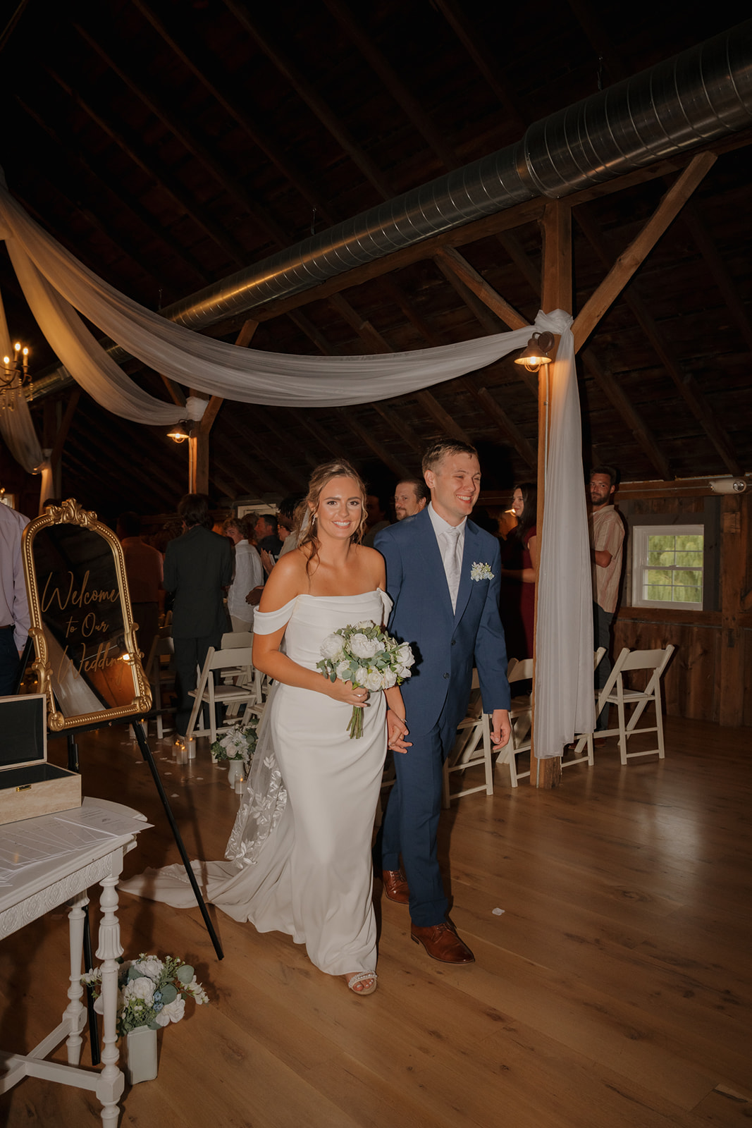 Couple walks hand in hand back down the aisle, smiling after the ceremony at a Wisconsin wedding venue.