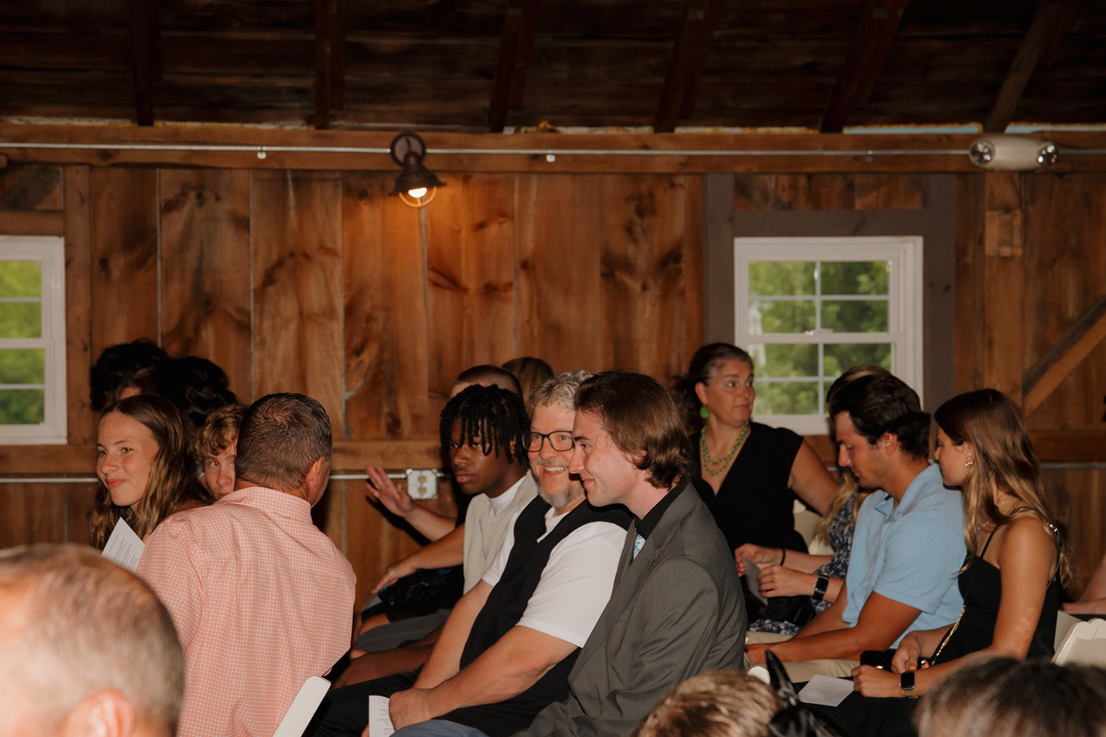 Wedding guests seated in rows, chatting and smiling as they wait for the ceremony to start.