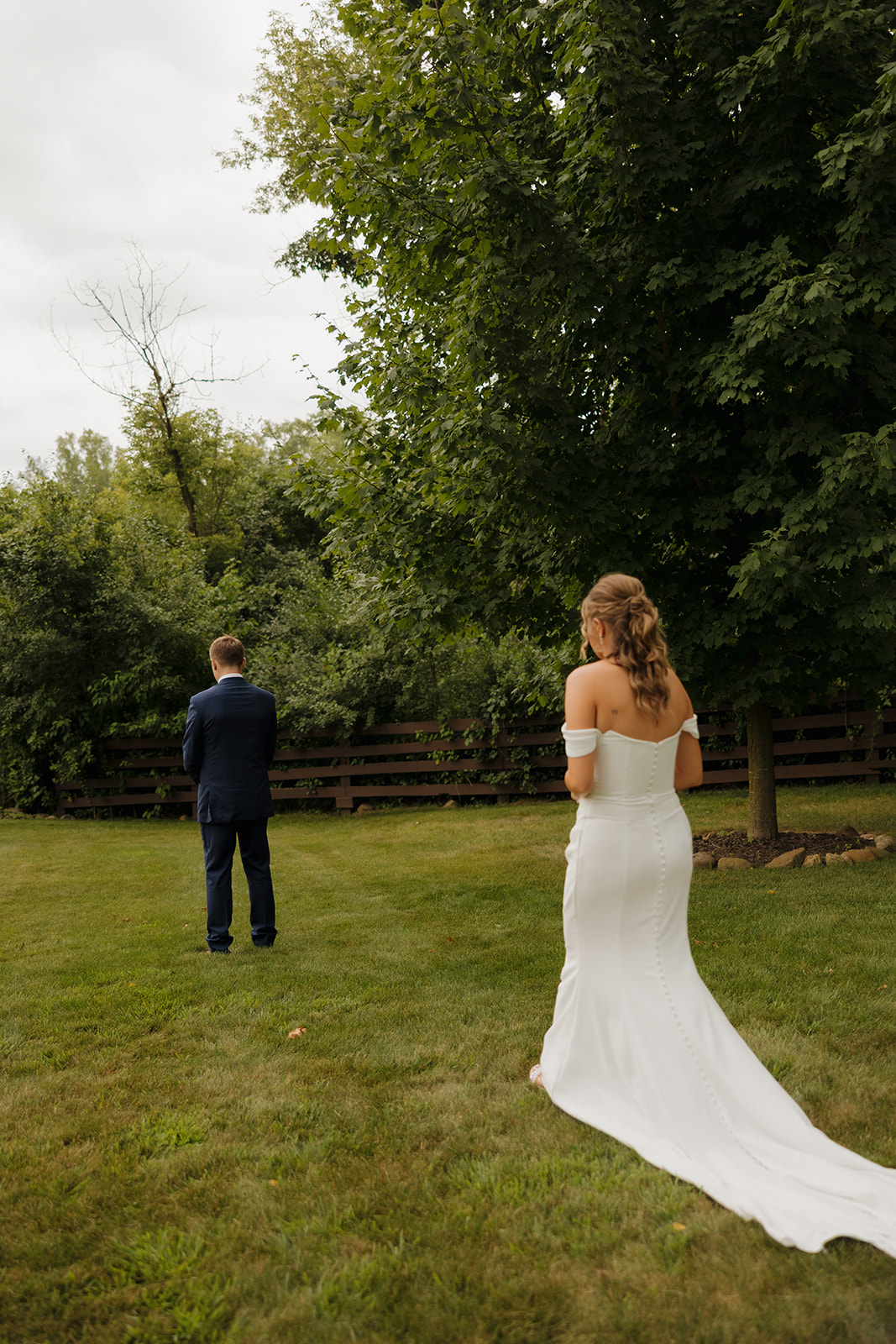 Bride approaching groom from behind during their emotional first look at a Wisconsin wedding venue.