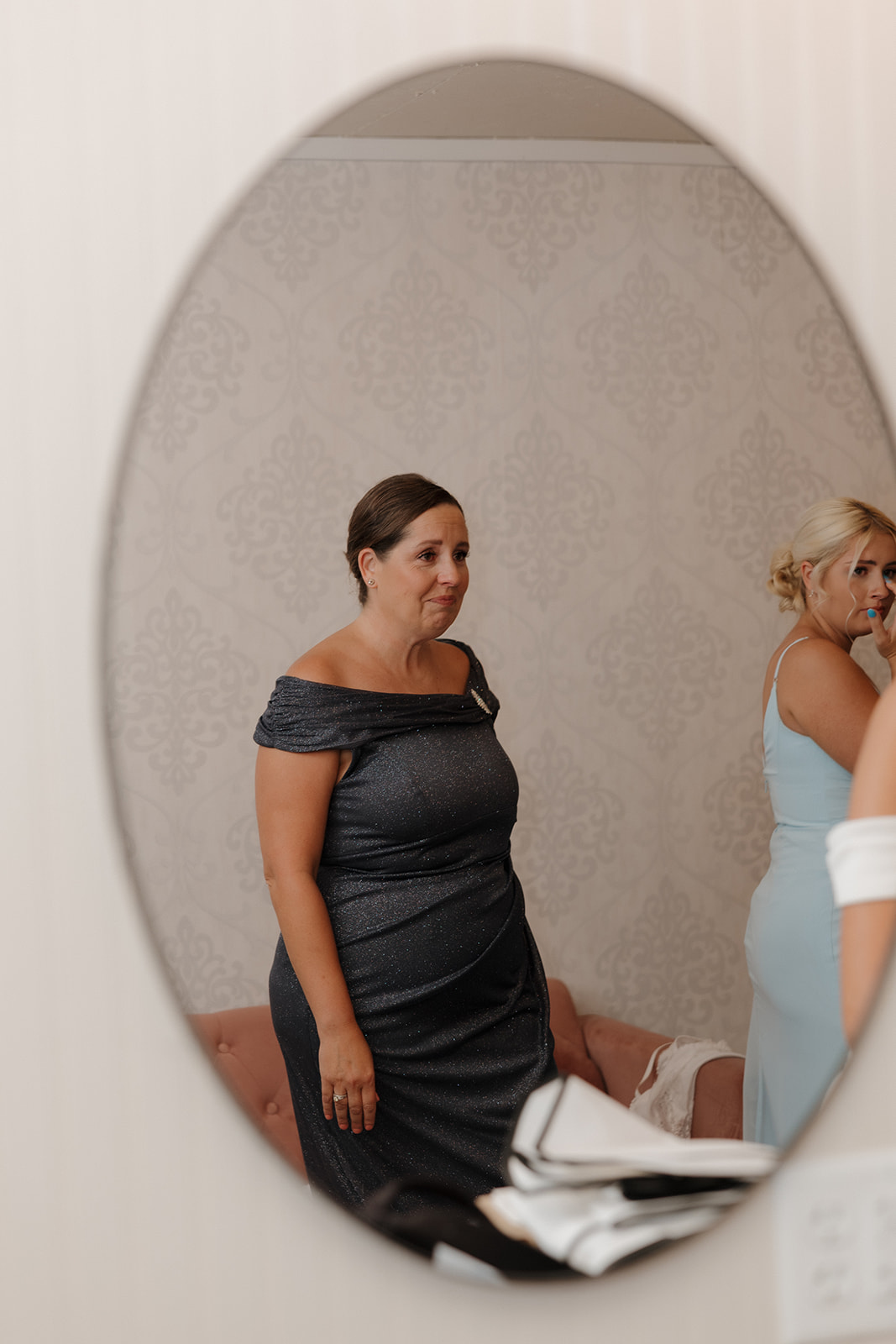 Mother of the bride tearing up while watching her daughter prepare for the big day.