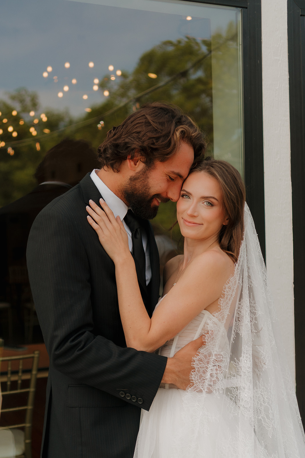 Romantic embrace as the groom nuzzles into his bride’s cheek while she gazes calmly at the camera—pure tenderness from weddings in Wisconsin.