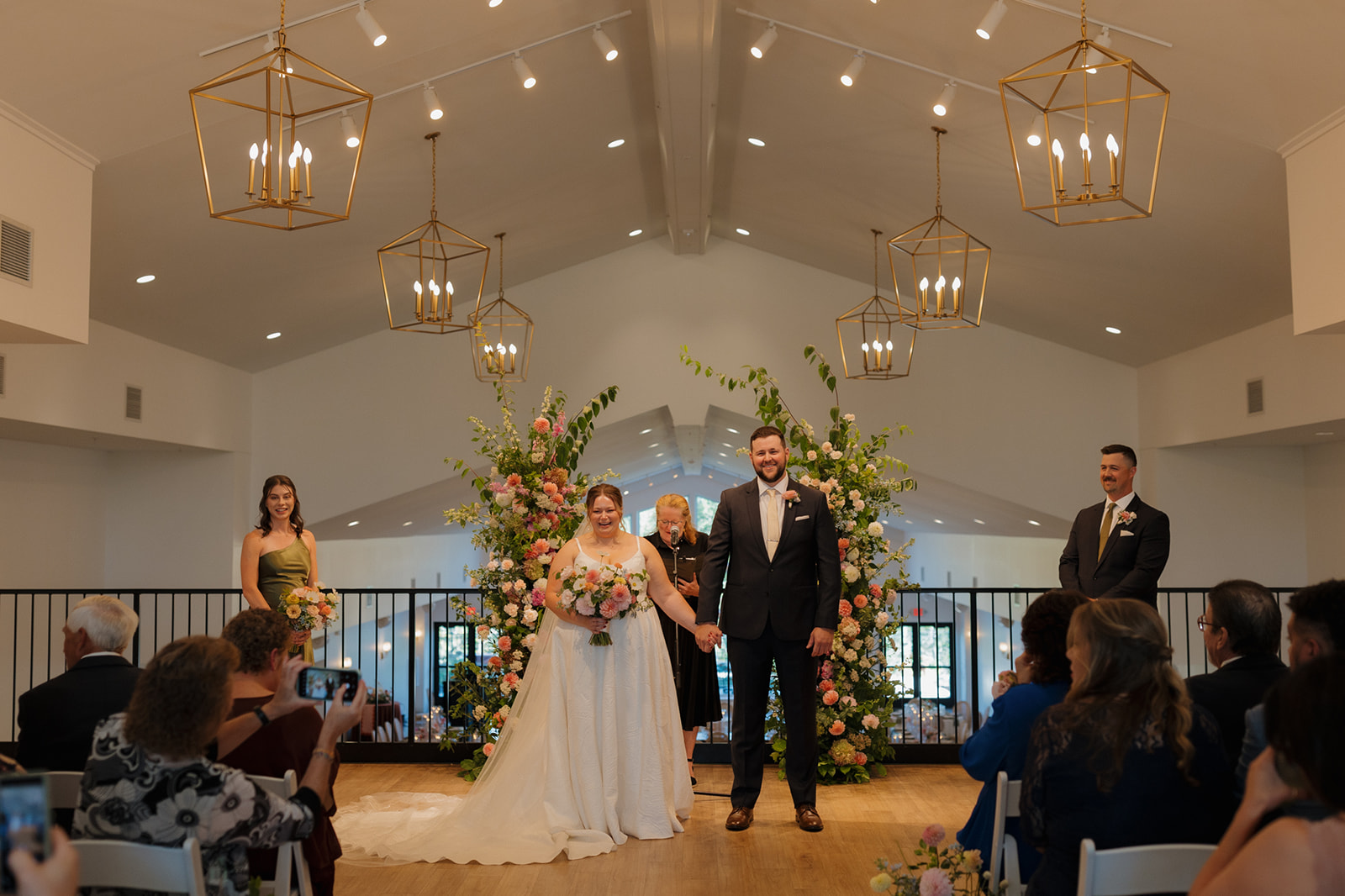 Just married and beaming—bride and groom celebrate at the altar as guests snap photos at a wedding venue in Wisconsin.