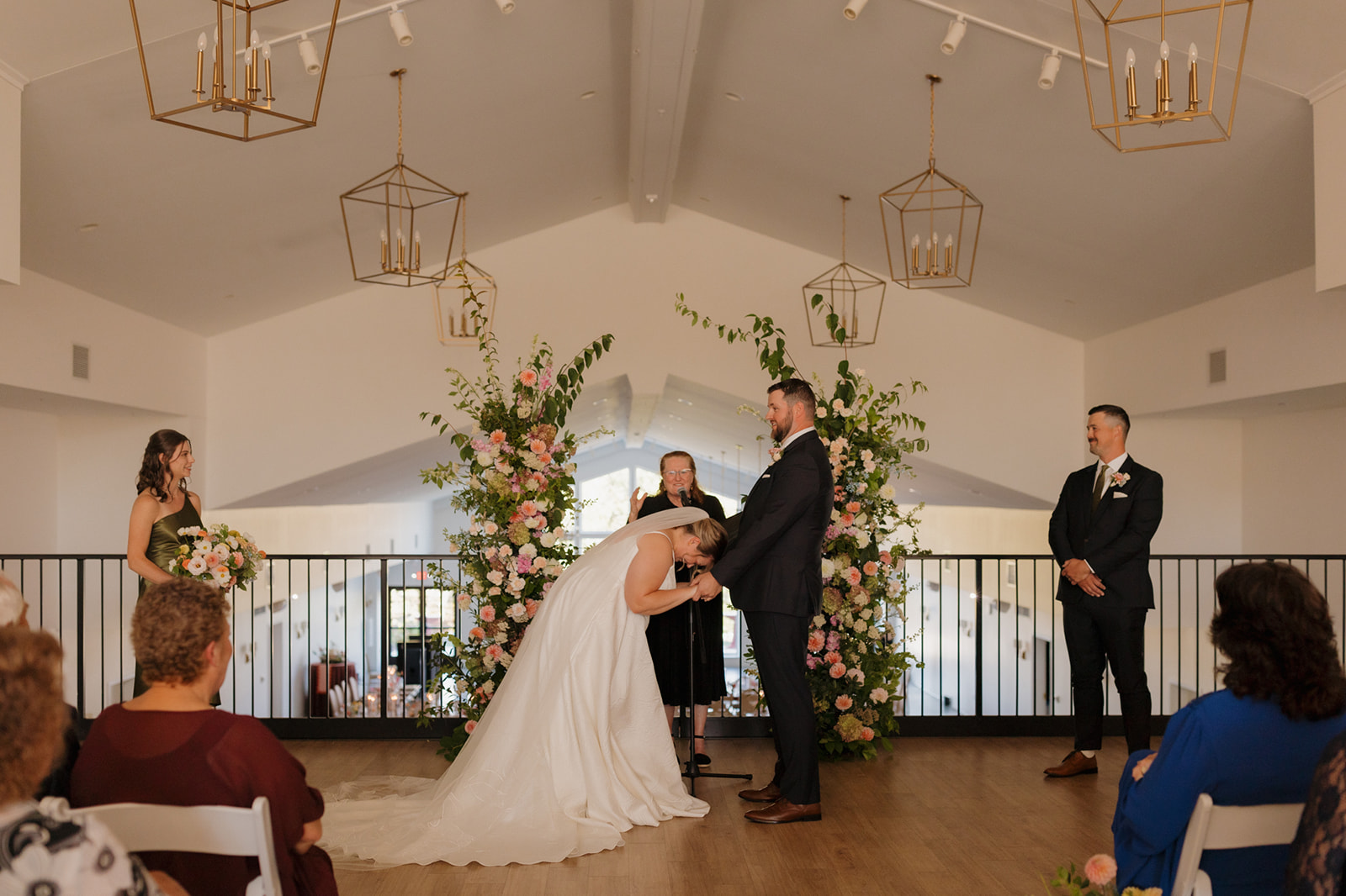 Bride playfully bowing to the groom during the ceremony, sparking laughter all around the light-filled venue.