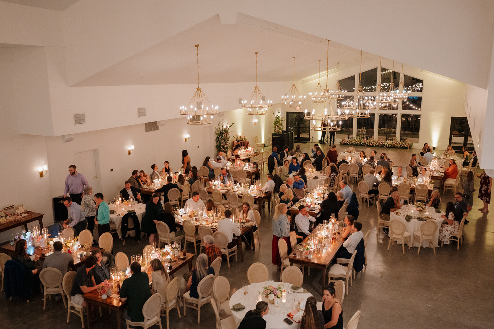Reception hall filled with candlelit tables and chandeliers at The Eloise, a wedding venue in Wisconsin.