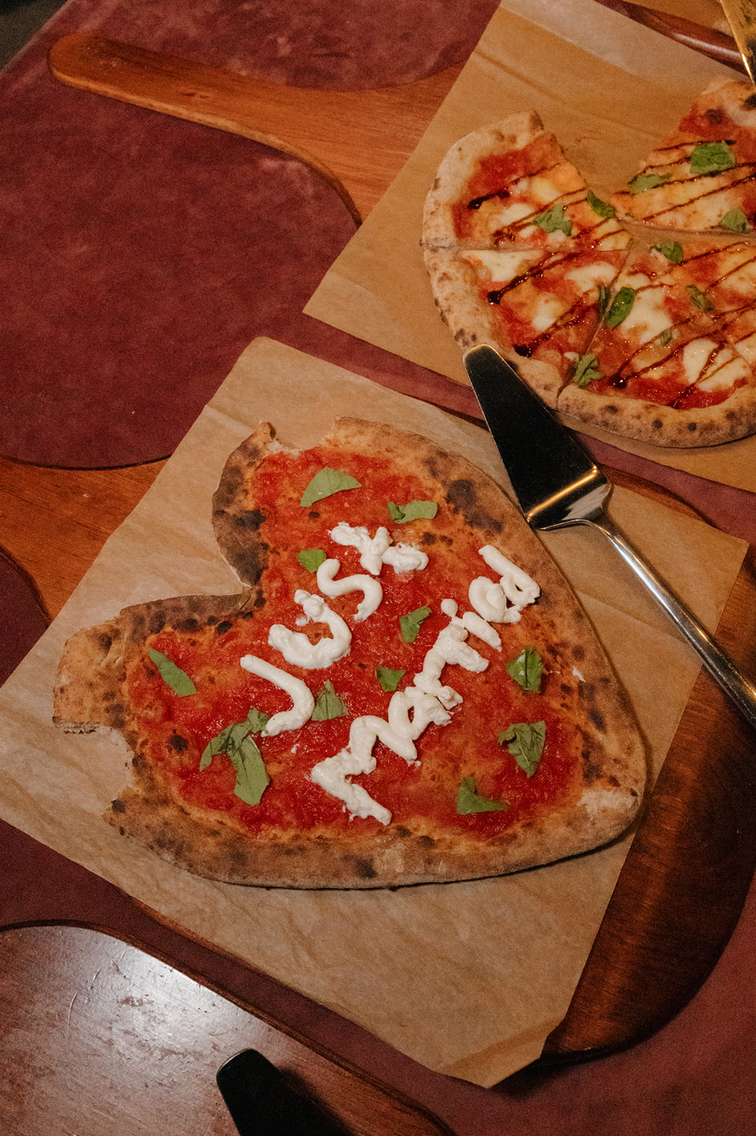 Heart-shaped pizza with “Just Married” written in cheese at a wedding venue in Wisconsin.