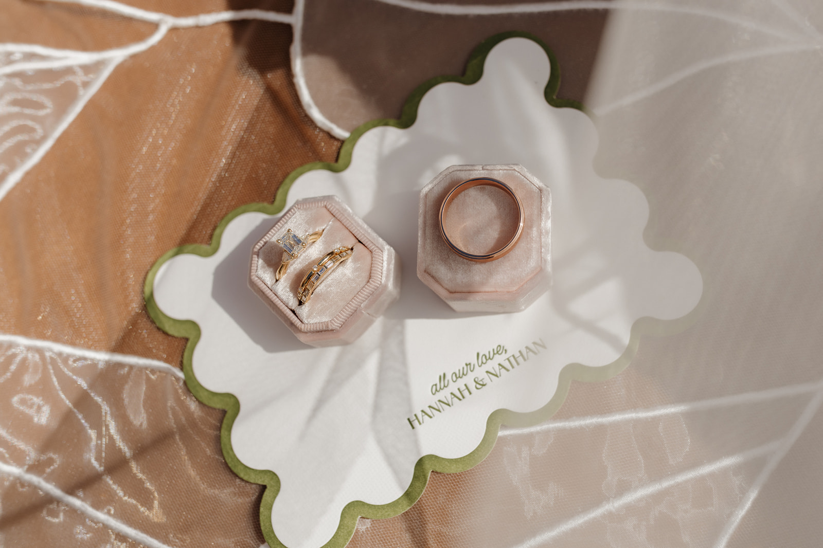 Wedding rings displayed in blush velvet boxes, styled on custom stationery at a Wisconsin celebration.