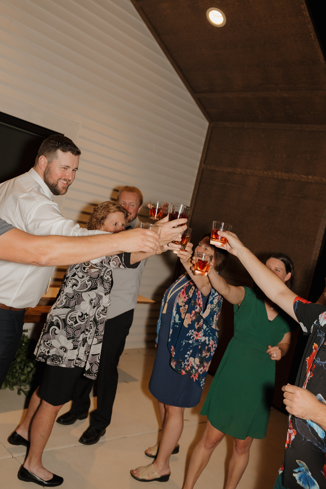 Wedding guests raise their glasses during a nighttime toast outside their wedding venue in Wisconsin.