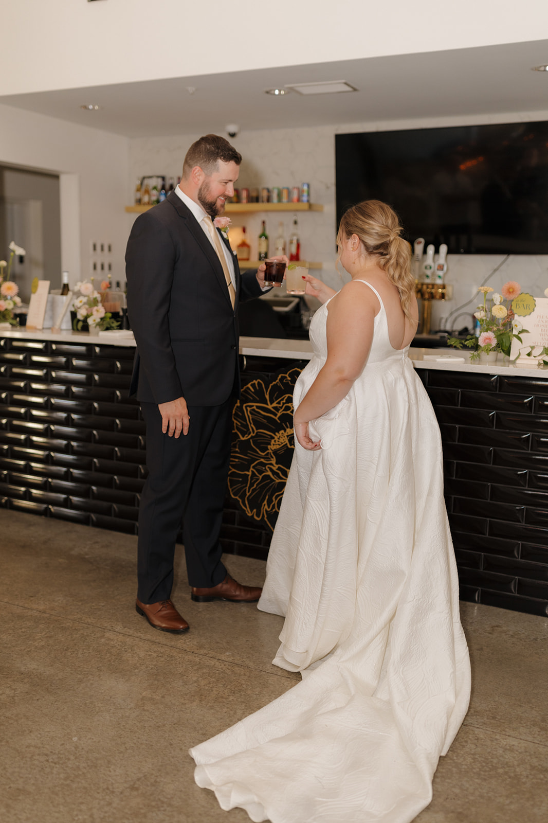 Newlyweds toast each other at The Eloise’s sleek black tile bar.