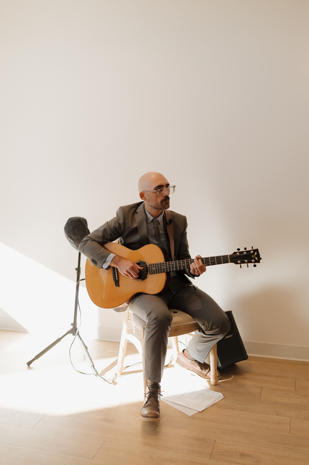 Solo guitarist in a light-filled room, playing soft ceremony music at a stylish Wisconsin celebration.