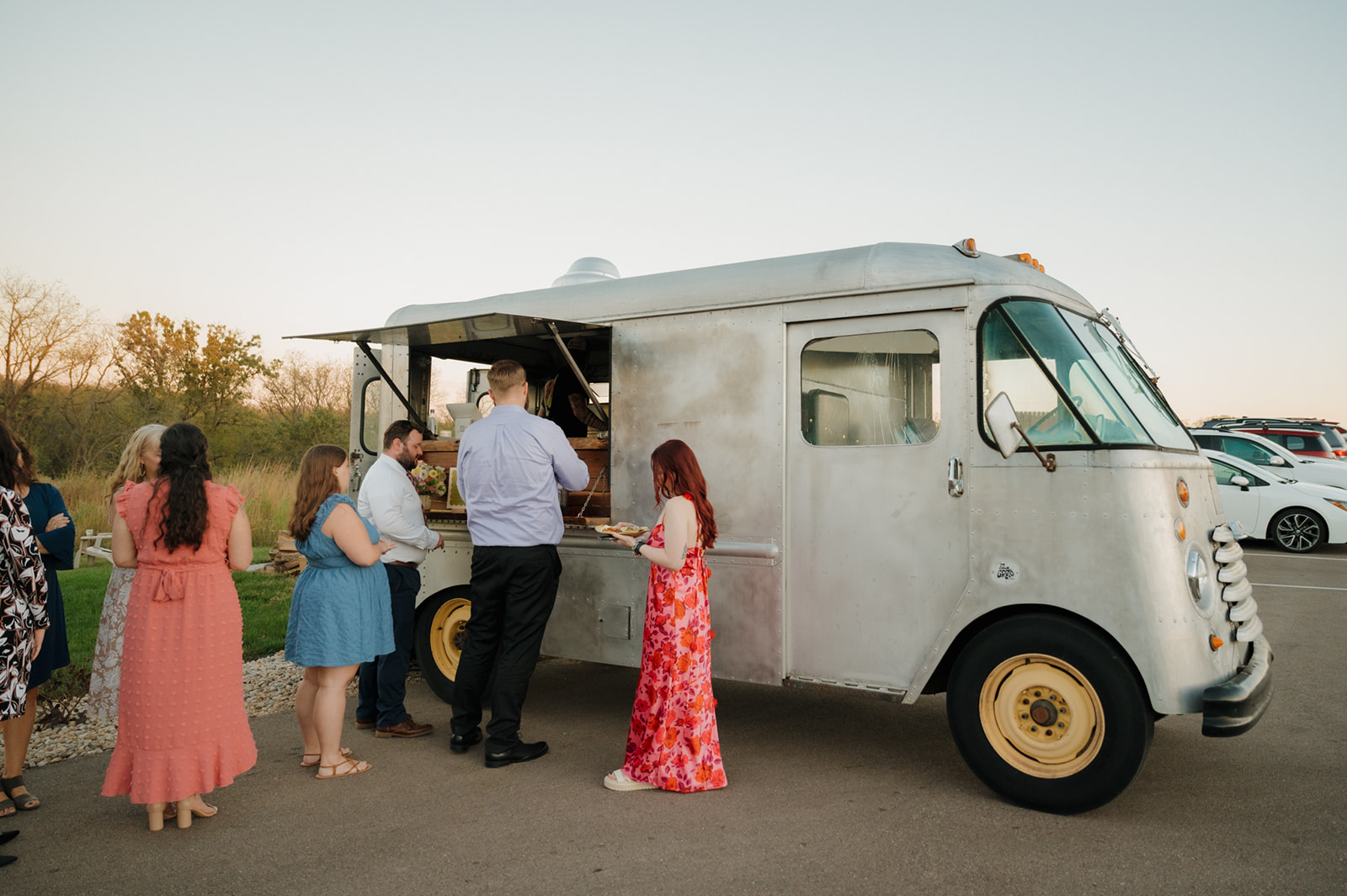 Guests line up at a vintage food truck for a fun wedding dinner experience.