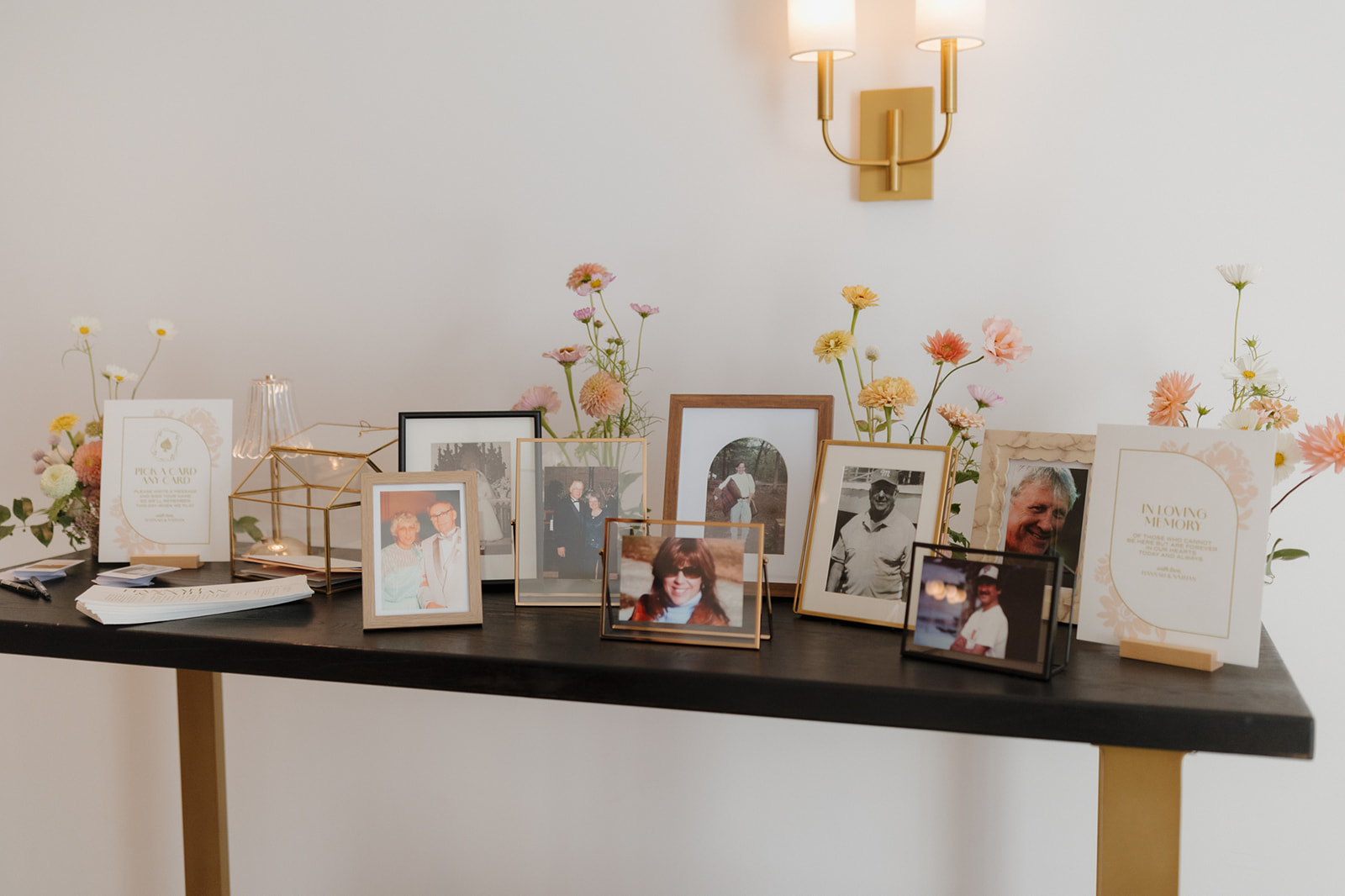 A memory table filled with framed family photos and flowers, honoring loved ones at a Wisconsin wedding.