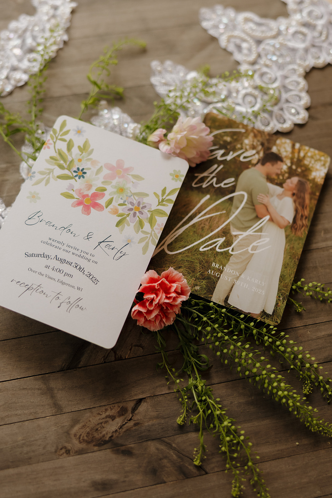 Elegant wedding stationery flat lay with floral details, lace accents, and a candid engagement photo.