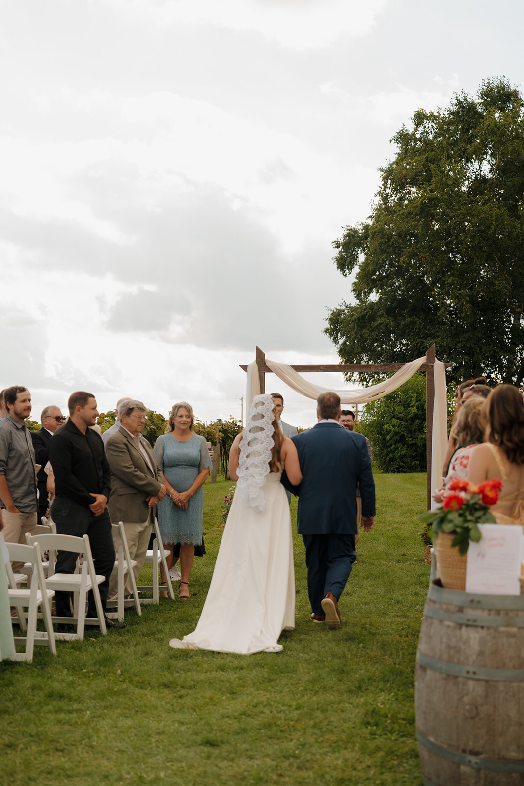 The bride makes her entrance down a grassy aisle at one of the most emotional and scenic Madison wedding venues.