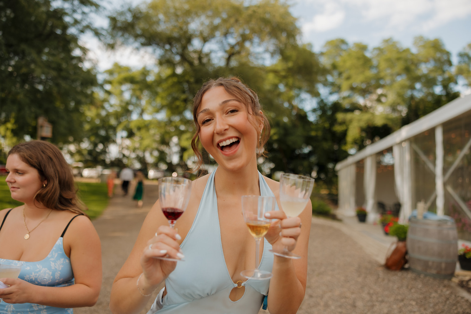 Joyful bridesmaid toasts with a mix of wine at a vineyard-style celebration, bringing that laid-back elegance Madison wedding venues are known for.