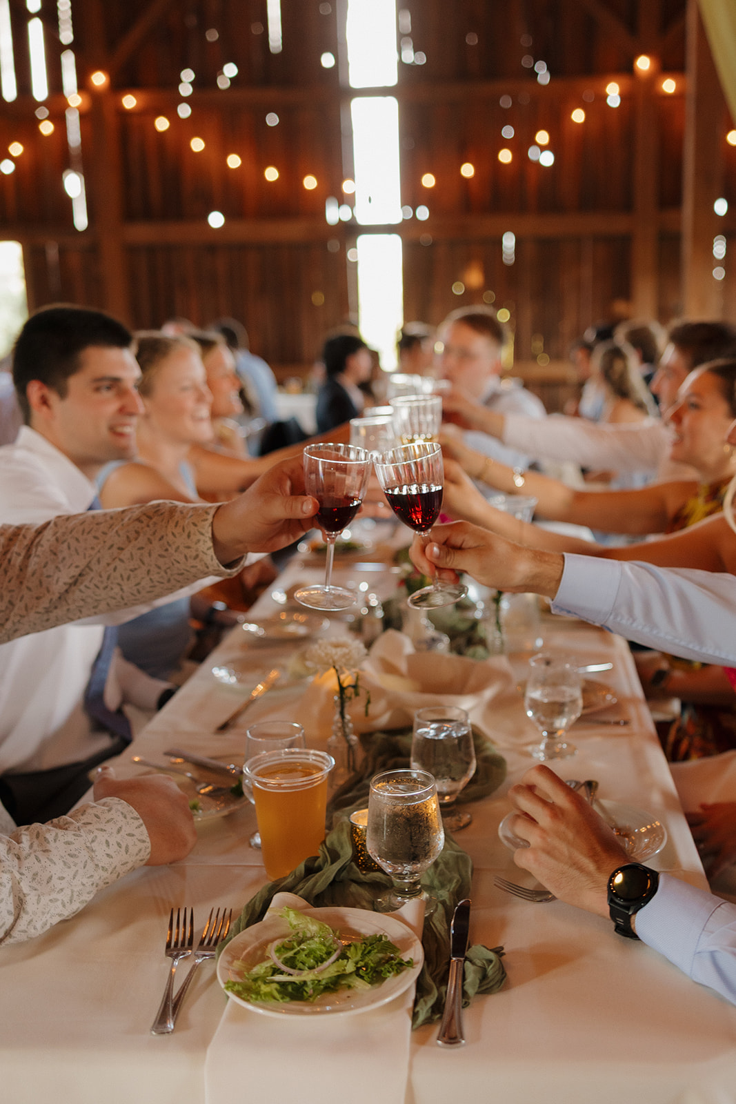 Dinner toasts begin in a warmly lit barn, one of those signature touches that make Madison wedding venues feel like home.