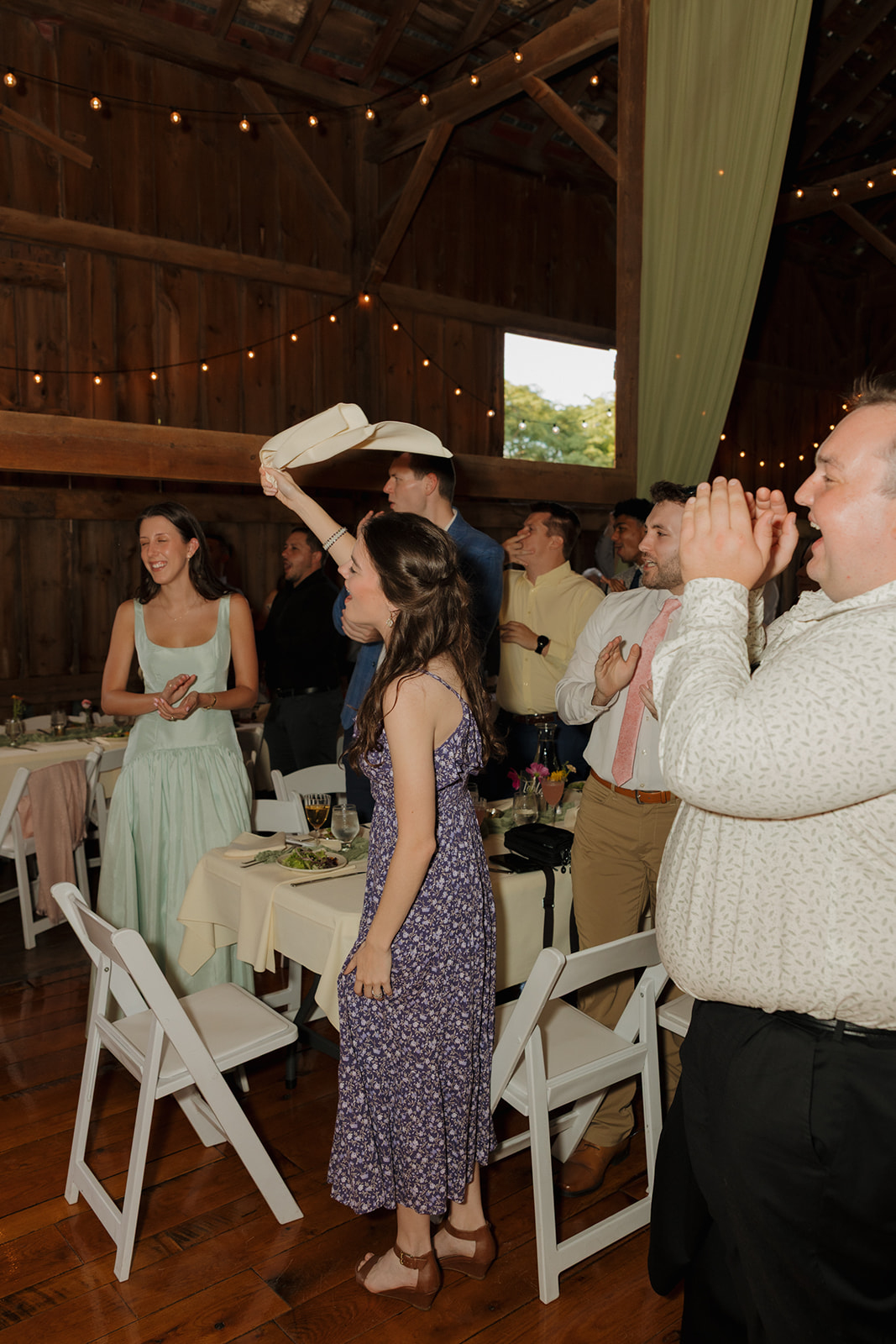 Reception energy is high as guests jump to their feet, clapping and celebrating the couple’s entrance.
