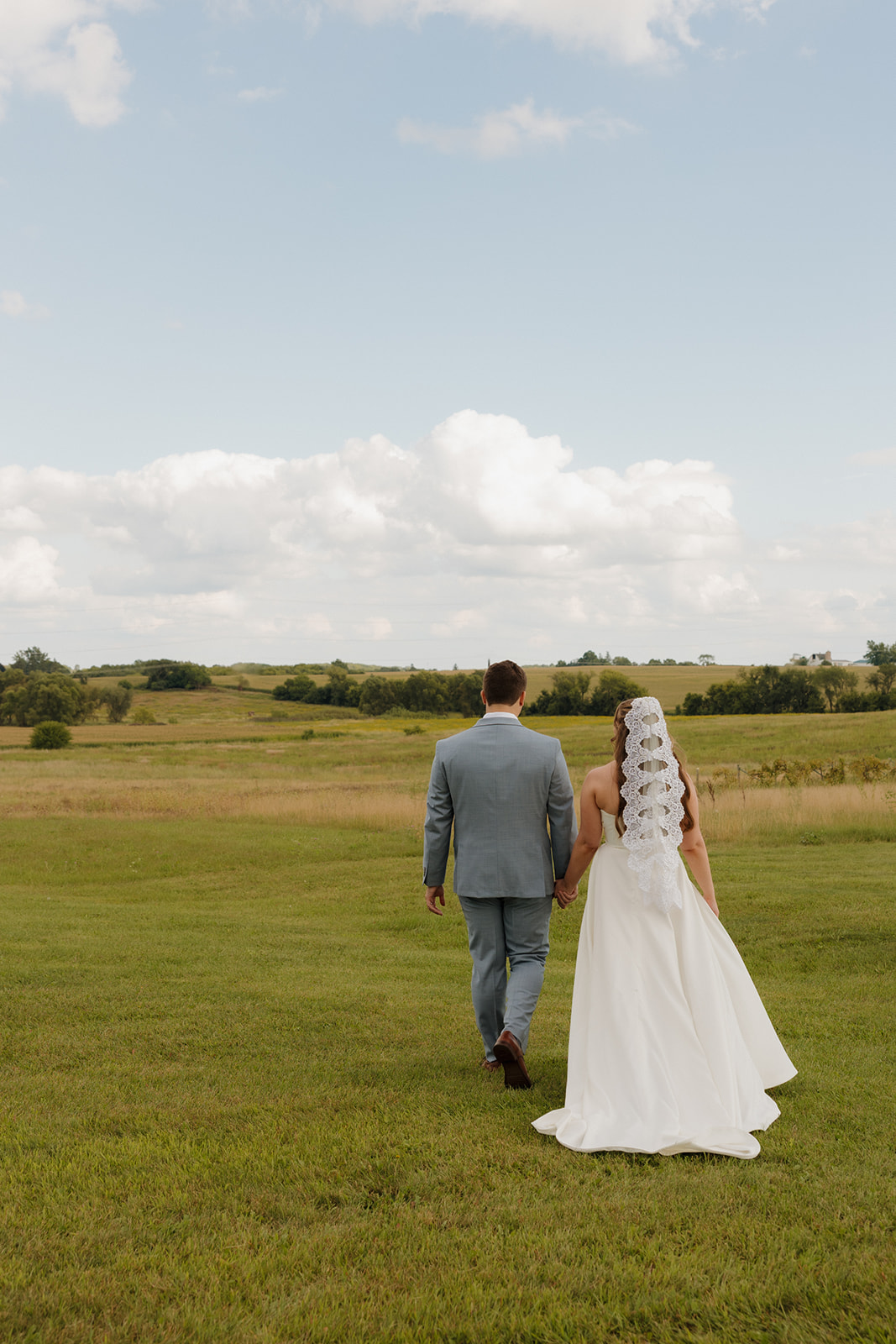 Peaceful moment as the couple walks together into the wide Wisconsin landscape, soft light casting long shadows.