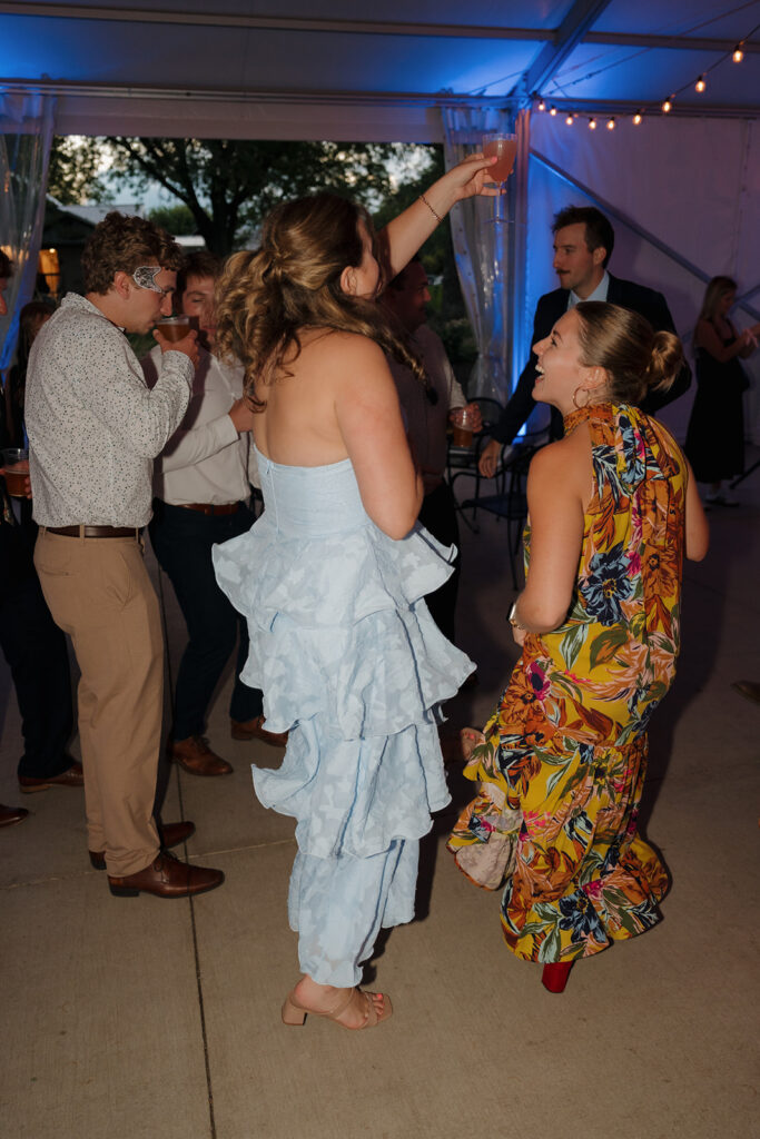 Cocktail in hand, music pumping—guests celebrate and let loose beneath the tented reception glow.