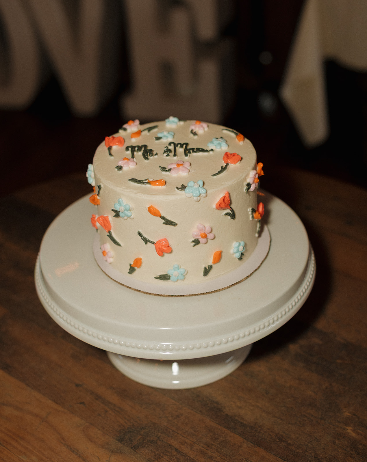 Whimsical single-tier wedding cake with colorful buttercream florals, perfect for intimate celebrations at Madison wedding venues.