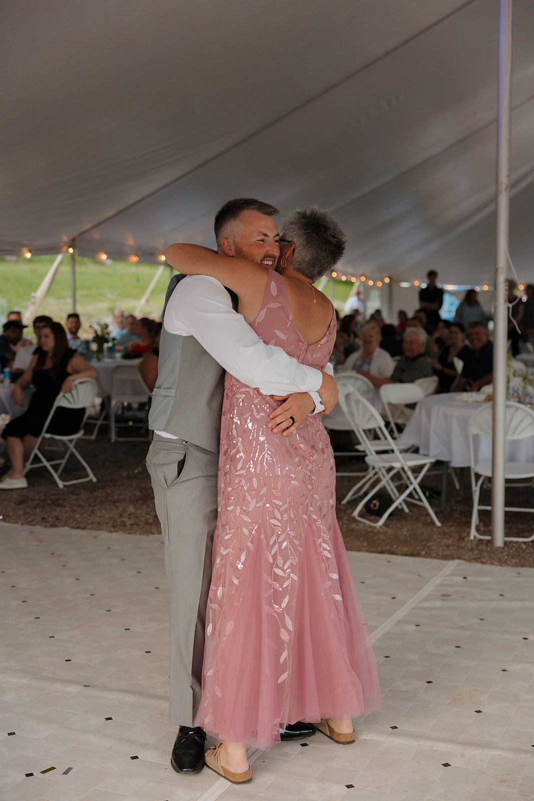Groom hugs his mother during a heartfelt dance at the reception.