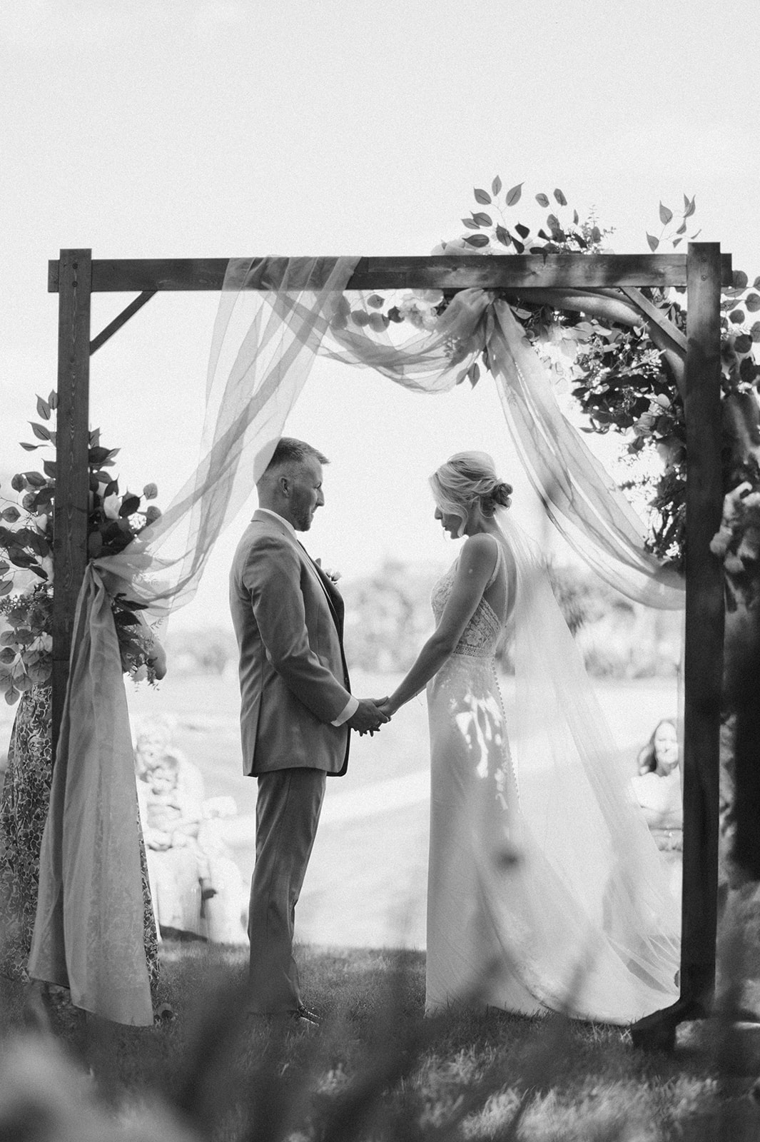 Intimate moment captured as couple holds hands during their vows.