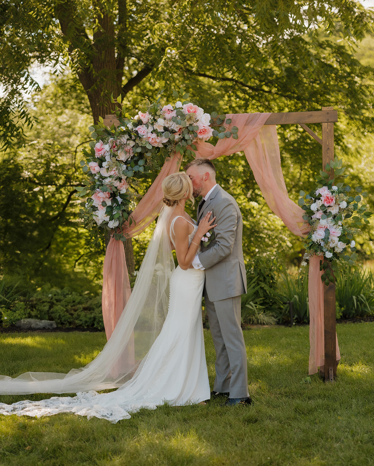 Newlyweds share their first kiss during their outdoor ceremony at a winery wedding venue in Wisconsin.